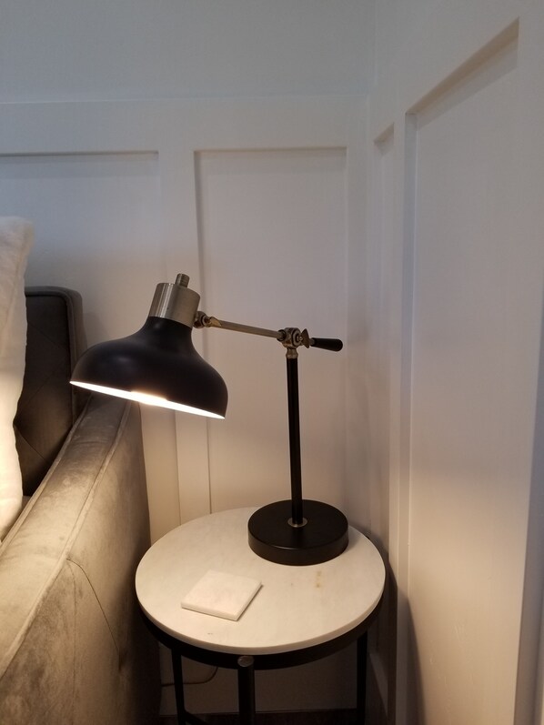 A round table with a black desk lamp, a white napkin, and a small white object on the table.