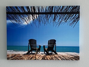 Relax in Adirondack chairs under a shaded deck overlooking the calm ocean.