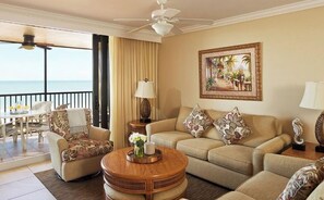 Relax in this stylish living room with a sofa, dining area, and ocean view.