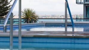 Ein Schwimmbad mit Blick auf eine Stadtlandschaft.