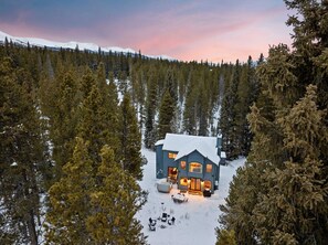 A large cabin surrounded by a dense forest, with a snow-covered roof and a visible deck area. - Peace and quiet just minutes from Breckenridge (Blue River)