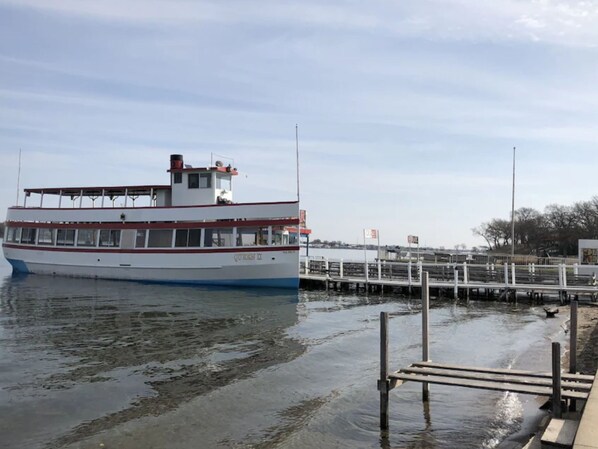 A white boat with red trim docked at a pier. - Arnolds Park Cozy Cottage & Gazebo Steps to Okoboji Lake & Park (Arnolds Park)