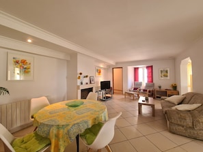 A living room with a dining area, a fireplace, a television, and a sofa. - Villa 'Casa tranquila torrox' with Mountain View, Pool, Garden, Terrace, A/C & Wi-Fi (Competa)