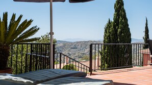 A balcony with a view of a mountainous landscape, a potted plant, and a striped cushion. - 'Villa mimosa nationalpark nearby' with Sea & Mountain View, Pool, Garden, Terrace, A/C & Wi-Fi (Cómpeta)