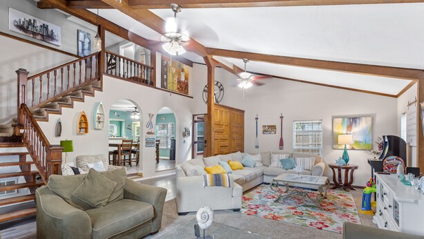 A spacious living room with a staircase, a sofa set, a coffee table, and a chandelier. - Fun Summer Lake House w/Firepit located in Ft Worth, Beds 18+, next to Marina  (Fort Worth)