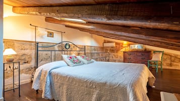 Een gezellig zolderkamer met een bed, een kast en een stoel.