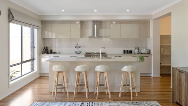 A modern kitchen with a central island, bar stools, and a large window. - Seagrove Escape - Near the beach & WIFI (Cowes)