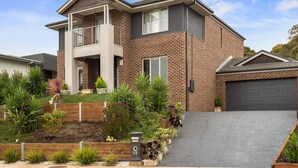 A two-story house with a balcony, brick exterior, and a driveway leading to a garage. - Seagrove Escape - Near the beach & WIFI (Cowes)