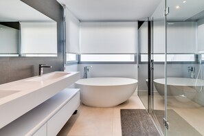 A modern bathroom with a large bathtub, a glass-enclosed shower, and a long vanity. - Villa 'Riva' with Sea Views, Wi-Fi and Air Conditioning (Marbella)