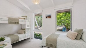 A bedroom with bunk beds, a large window with a view of the outdoors, and a small bedside table with a plant. - Moonah Cottage Rye by Ready Set Stay- Close to the beach & WIFI (Rye)