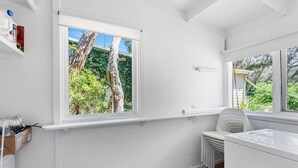A white-walled room with a large window, a radiator, and a white chair. - Moonah Cottage Rye by Ready Set Stay- Close to the beach & WIFI (Rye)