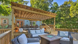 A covered outdoor deck with wicker furniture, a fire pit, and a dining area. - Dock & Jet Ski Slip: Lakeside Sunrise Beach Home! (Sunrise Beach)