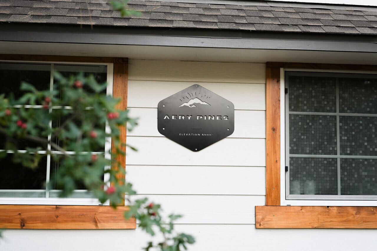 A house with a sign that reads "Avery Pines" and "Elevation 8000".