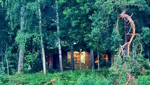 A cabin surrounded by dense forest, with a body of water in the foreground. - A Real Home - sea View Close to City Center (Pargas)