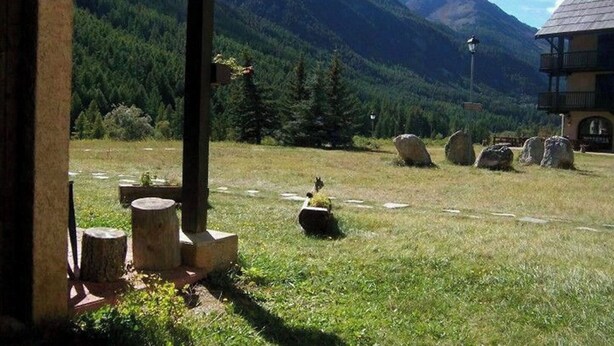A rustic outdoor area with a stone bench, a wooden table, and a stone sculpture. - SiFa - Studio with mountain corner and terrace close to shops (Névache)