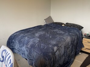 Cozy retreat with a large bed and a nightstand featuring a bottle and glasses.