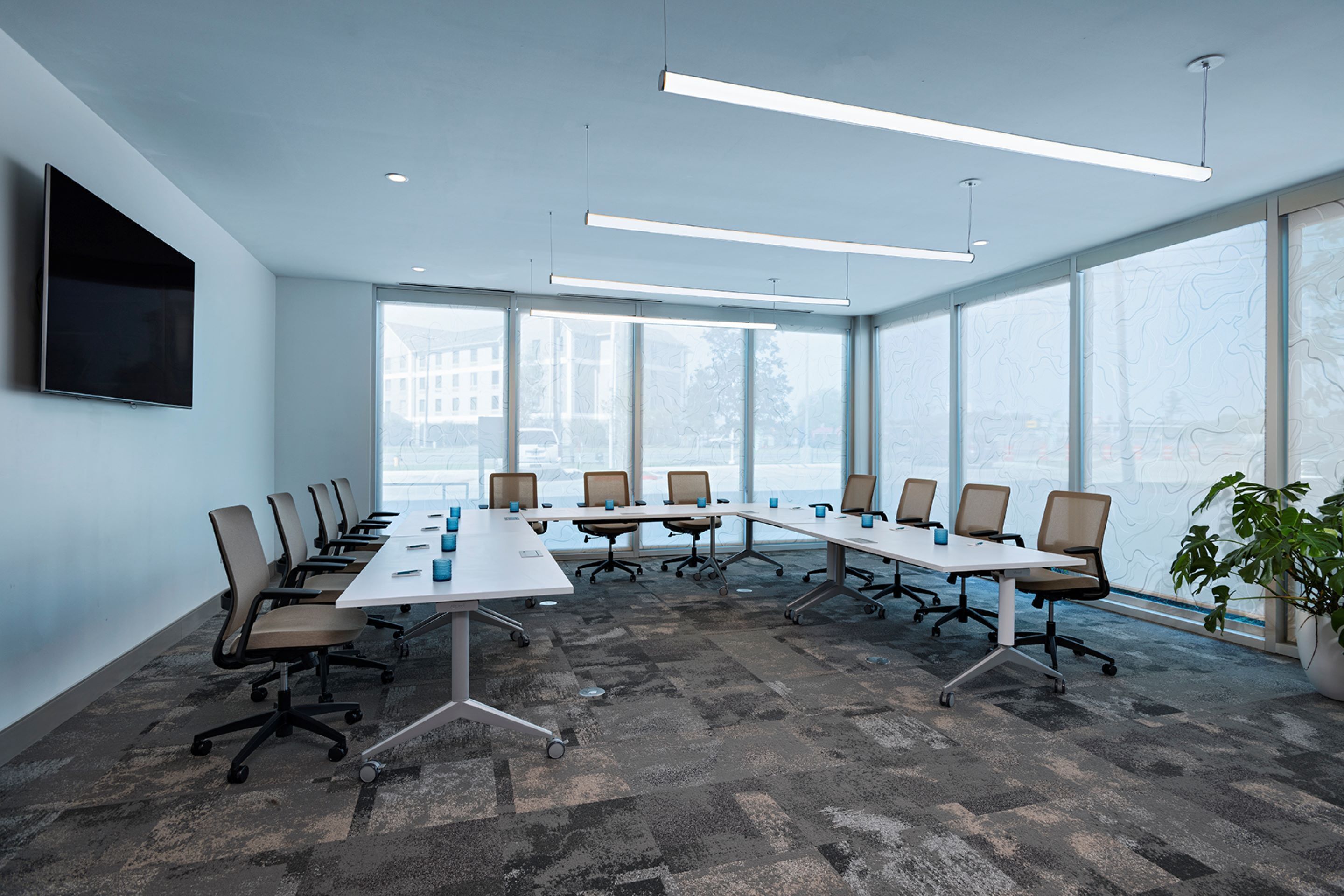 A conference room with a long table, chairs, and a large window.