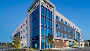 A modern hotel building with a prominent 'Element by Westin' sign, large windows, and a parking area.