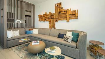 Una sala moderna con un sofá seccional, una mesa de centro y un elemento decorativo de madera en la pared.