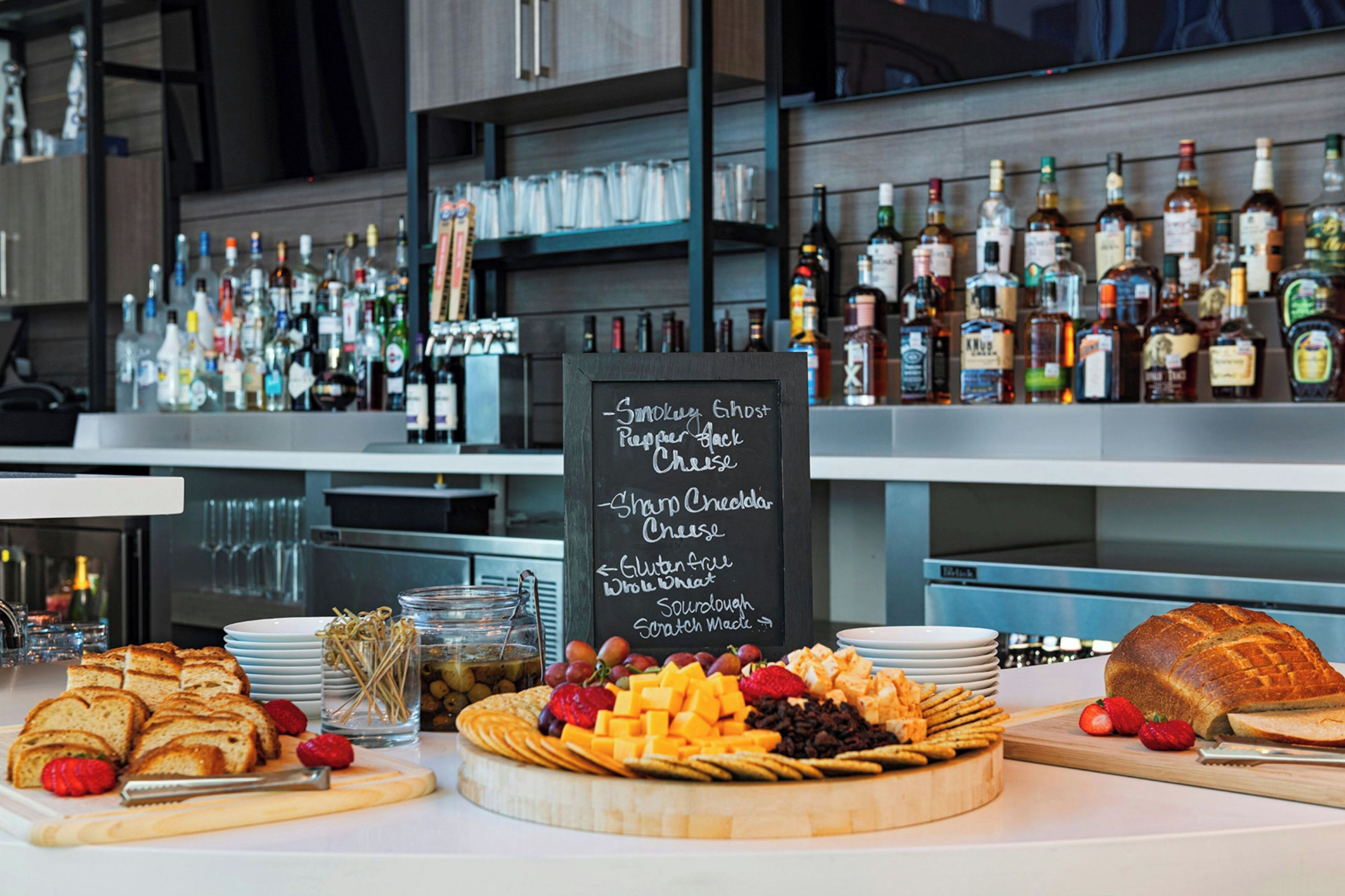 Una mesa de buffet con una selección de quesos, frutas y galletas.