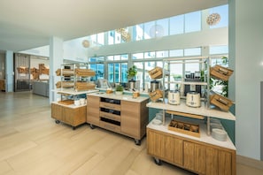 Una cocina moderna con armarios de madera, una isla central y vistas amplias a través de grandes ventanales.