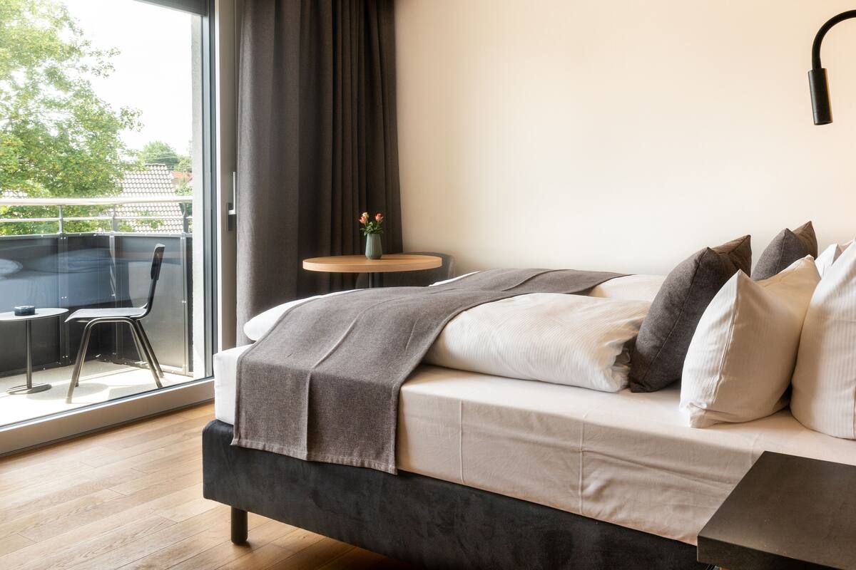 Une chambre à coucher moderne avec un lit, une petite table ronde et une chaise.