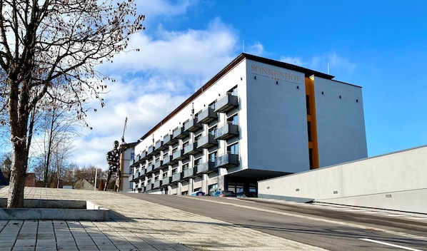 Un edificio moderno con un letrero que dice "SONNHOF" y varios balcones.