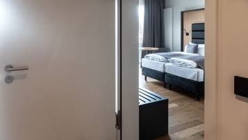 A modern bedroom with a bed, bedside table, and a view of the outside.