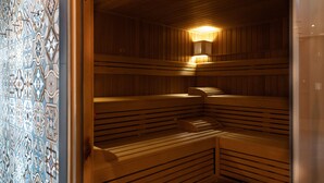 A sauna with wooden benches and a tiled wall. - Burgau Hotel Sonnenhof (Burgau)
