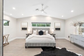 A spacious bedroom with a large bed, a ceiling fan, and a window providing natural light. - Refined Arcadia Estate | Chef's Kitchen | Minutes to Scottsdale Nightlife (PHOENIX)