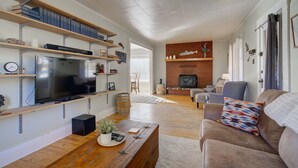Una sala de estar con televisión, estanterías de madera, chimenea y sofá.