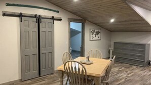 A dining area with a wooden table and chairs, a sliding door, and a dresser. - Golden Views In Every Direction! (Ennis)