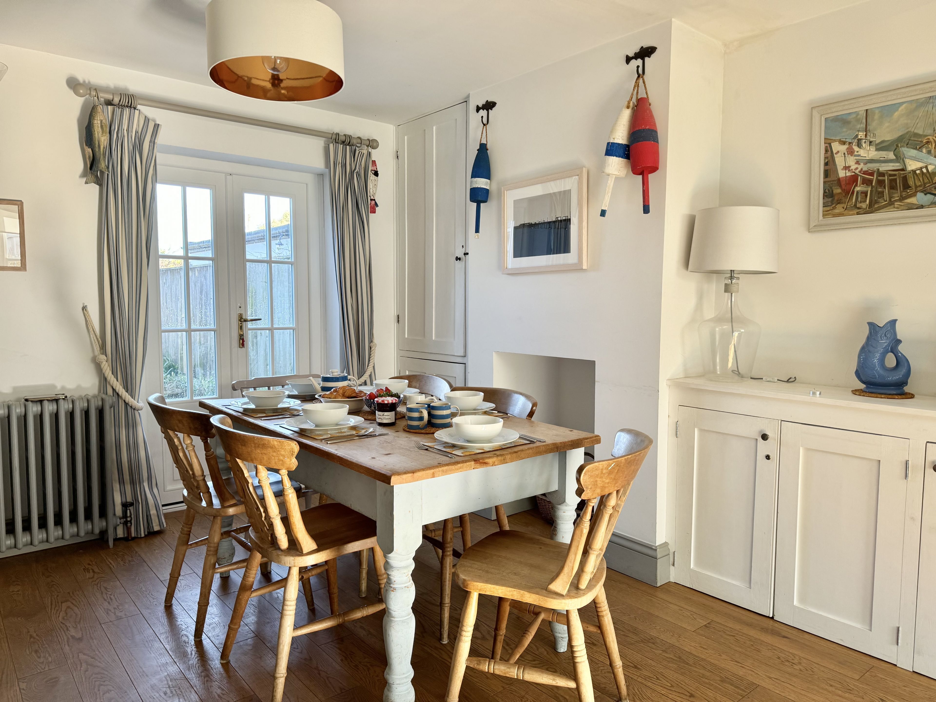 Un coin repas avec une table en bois, des chaises et une vue sur l’extérieur par une fenêtre.