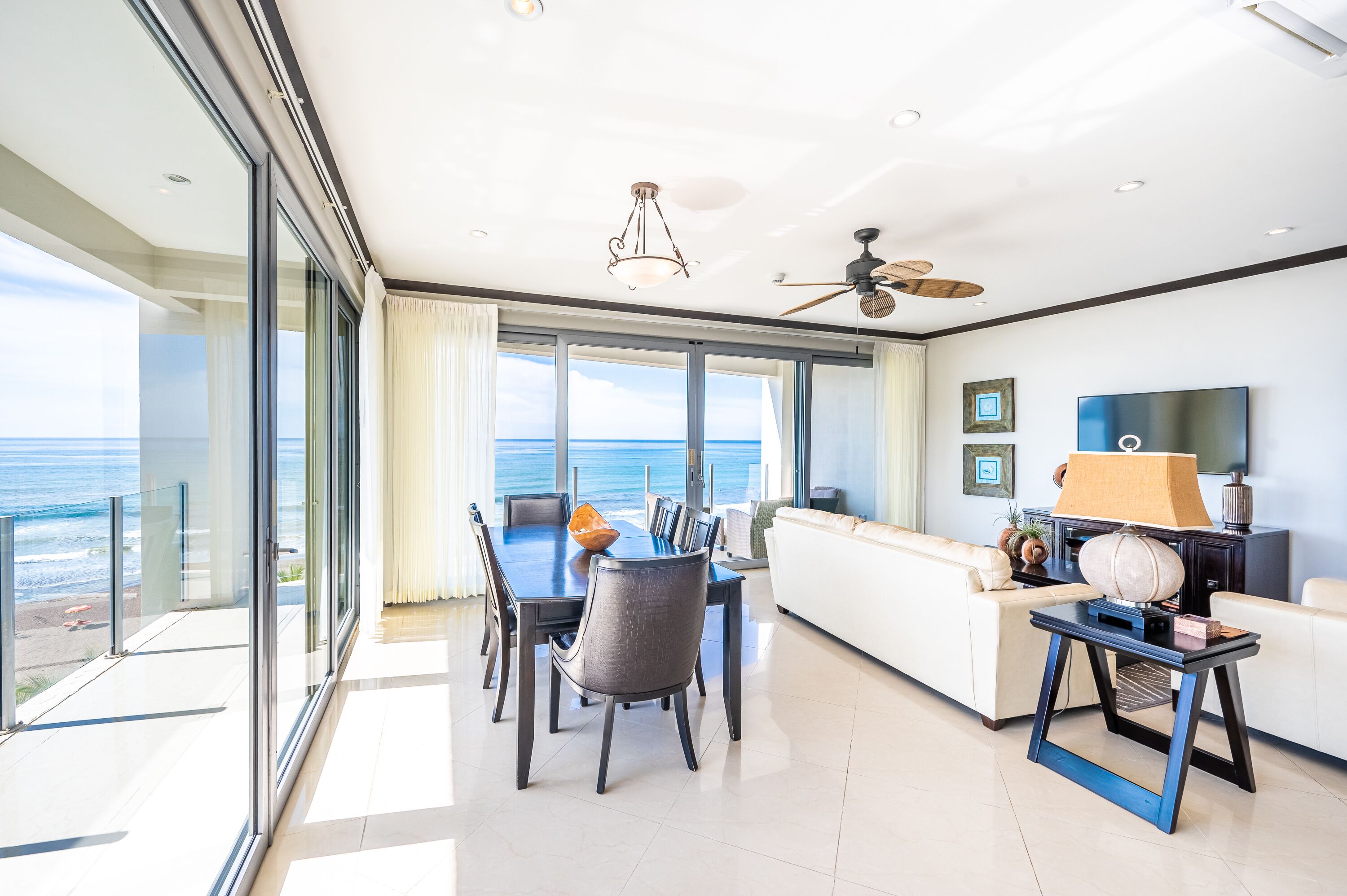 A spacious living area with a dining table, a sofa, and a TV.