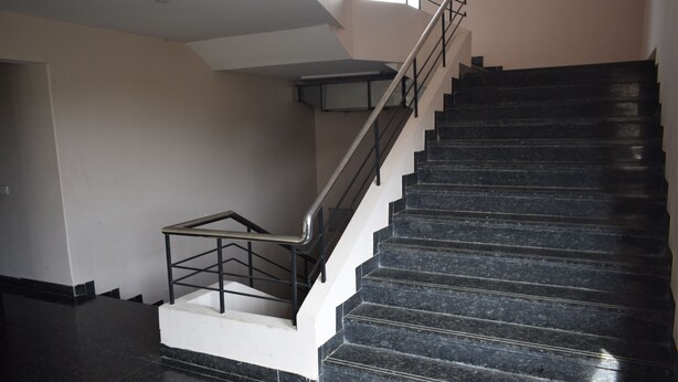 A staircase with black marble steps and metal railings. - Hotel Vijay Krishna (Madurai)