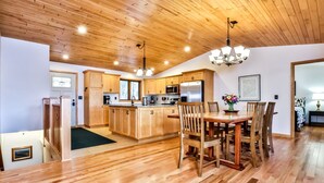 A spacious kitchen with wooden cabinets, a central island, and modern appliances. - Gorgeous Private Home with magnificent lake views! Great Firepit to watch the Su (Harshaw)
