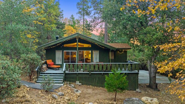 A cabin with a porch, outdoor seating, and a deck.