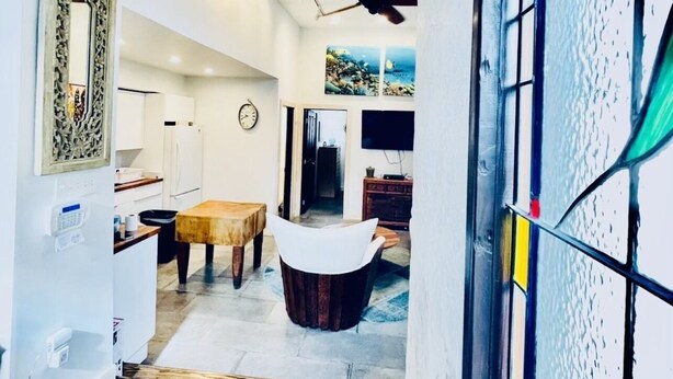 A modern interior with a dining area, kitchen, and a view of the outside. - coral stone 28 day minimum rental  (Key West)