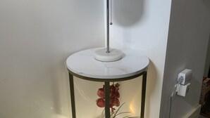 A corner table with a white marble top, a metal base, and a white lampshade. - coral stone 28 day minimum rental  (Key West)