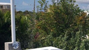 Una piscina en la azotea con rociador, rodeada por una valla decorativa blanca y un piso de baldosas.