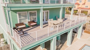 A two-story building with a balcony, outdoor seating area, and a pool.