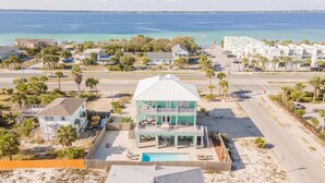 Una proprietà sul lungomare con piscina, un edificio a due piani e vista sull'oceano.