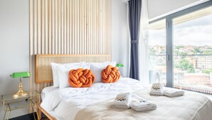 A hotel room with a large bed, a wooden headboard, a green lamp, and a view of the city through a large window. - Benesta Residence By Newinn (Istanbul)