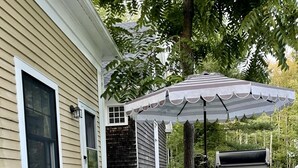 A wooden deck with a white railing, a patio umbrella, outdoor furniture, and a cactus plant. - Historic Kennebunkport home only 0.3 miles to Dock Square (Kennebunkport)