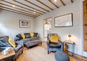 Relax in this inviting living room with a sofa, armchair, and reading nook.