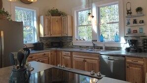 Una cucina moderna con mobili in legno, un piano di lavoro nero e una lavastoviglie integrata.