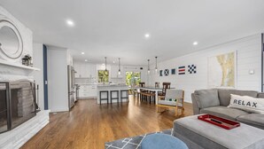 A modern kitchen with white cabinets, a central island, and pendant lighting. - Captains Cove, hot tub walk to Douglas! (Douglas)