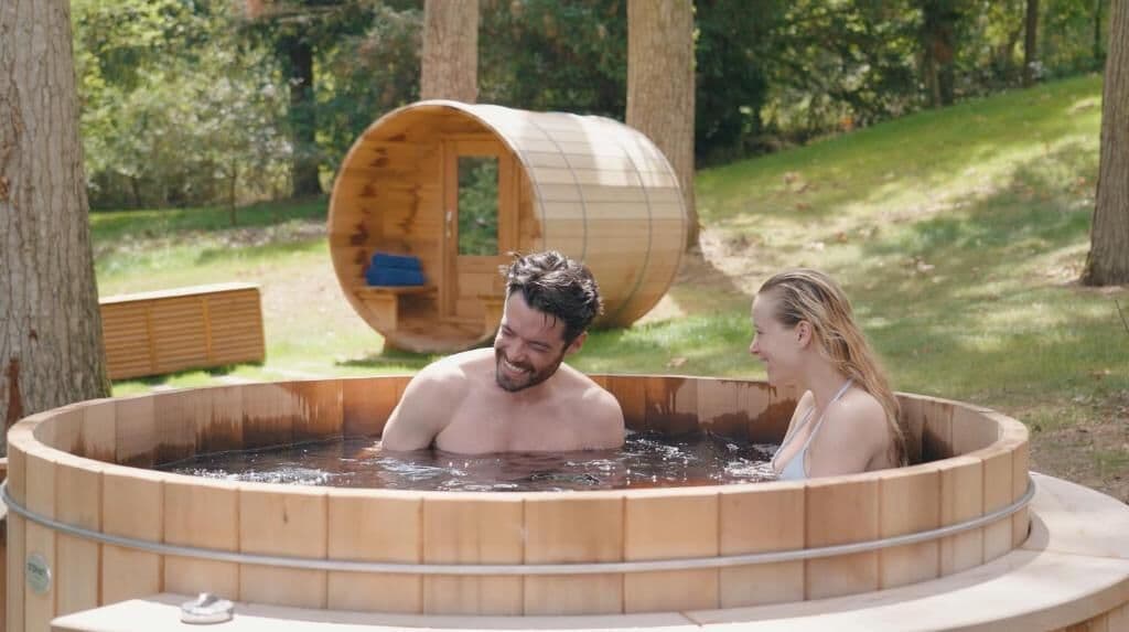 Ein Whirlpool in einer runden Holzkonstruktion, umgeben von Bäumen.