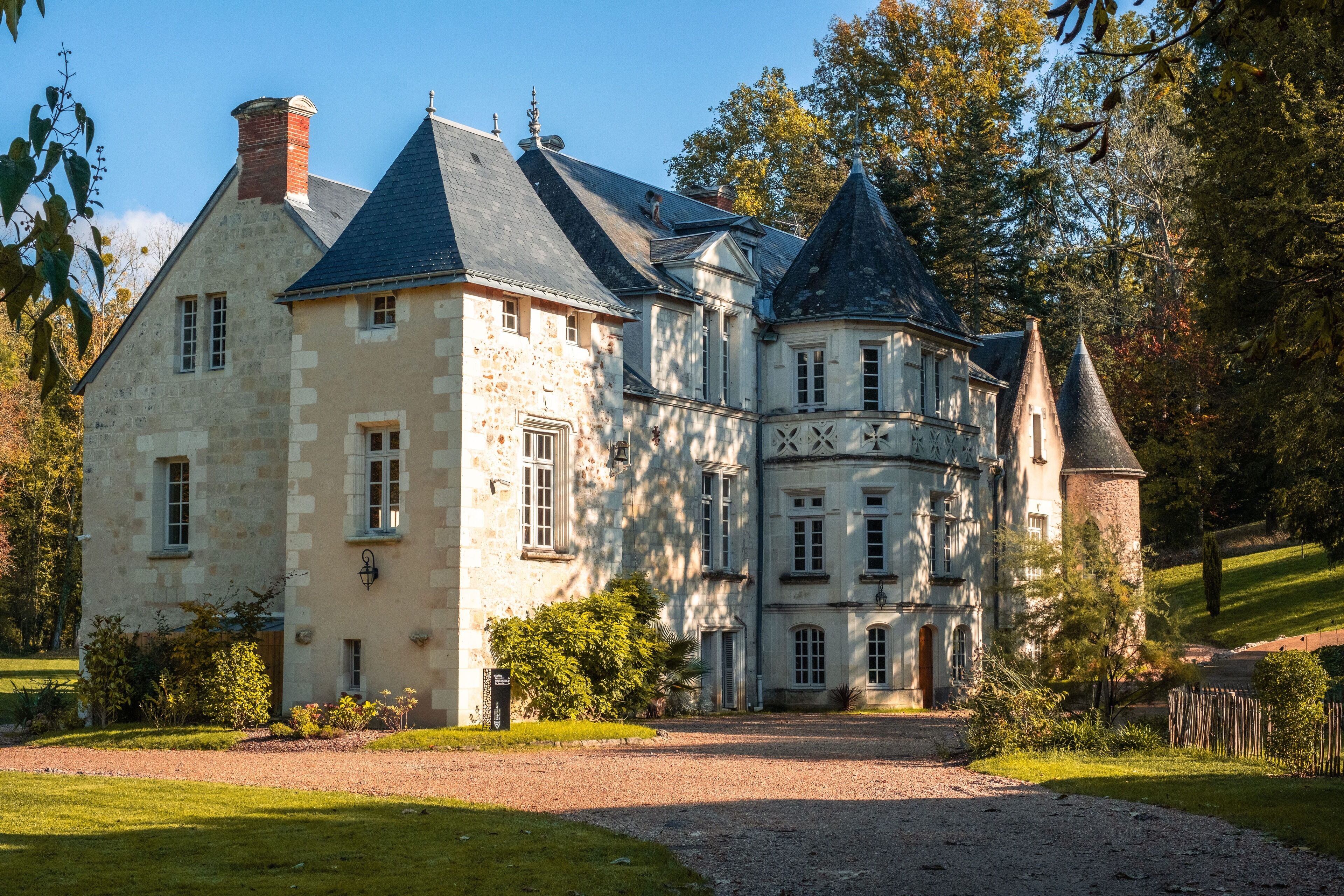 A large, historic stone building with multiple towers and a central courtyard.