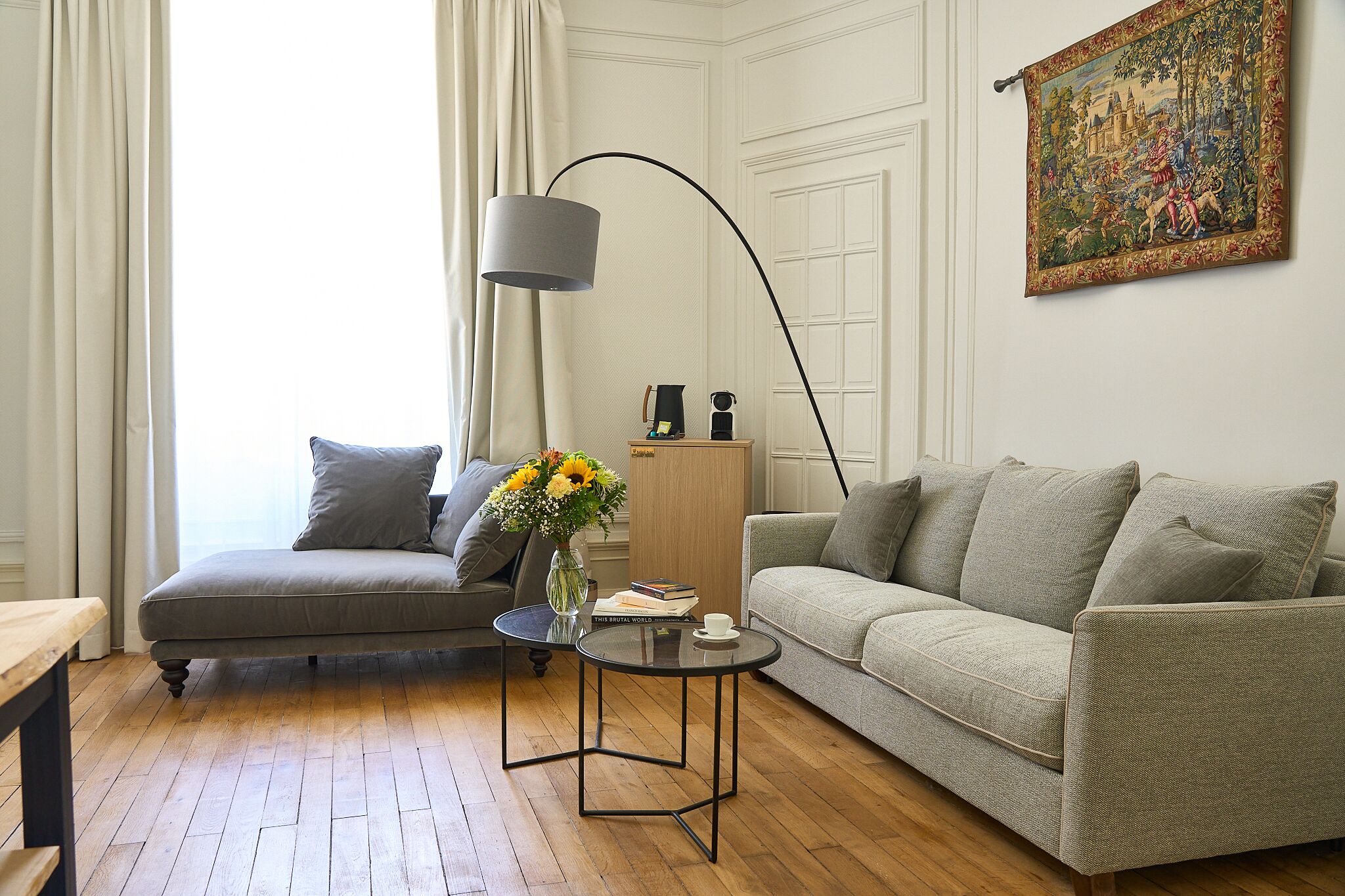A living room with a sofa, a coffee table, a lamp, and a painting on the wall.